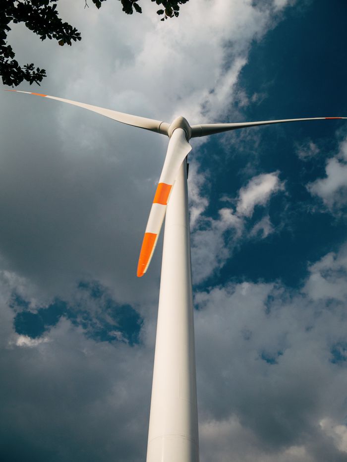 Close-up of a wind turbine and clouds, symbolizing clean energy solutions.